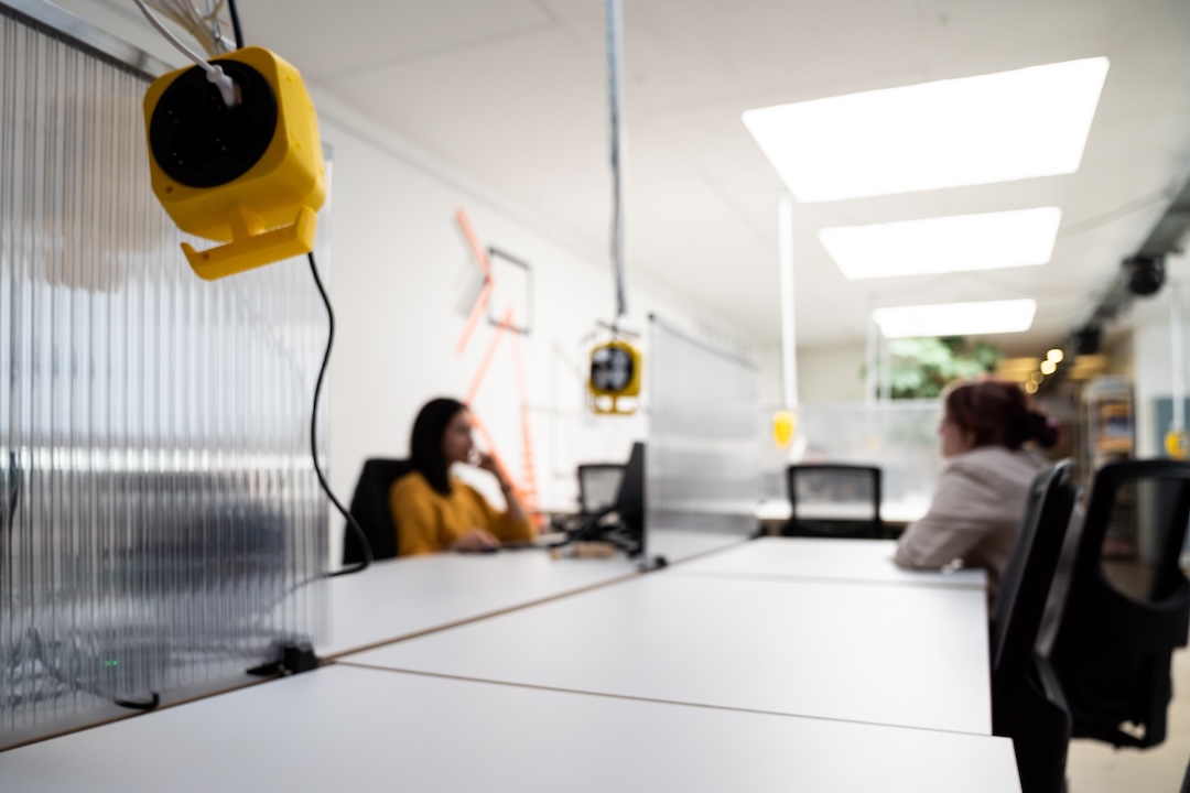 Bei Coworking Nürnberg können sich die Member einen freien Schreibtisch im Artbeitsbereich aussuchen An großen Schreibtischen können Coworker:innen ihrer Arbeit nachgehen